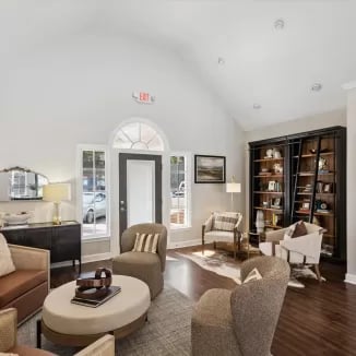 Seating area with bookshelves and large windows living room at Eighteen18 at Southern in Statesboro Student Accommodation
