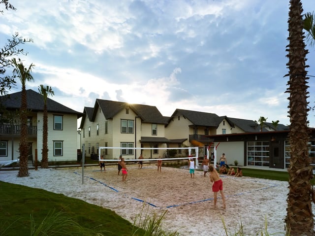 People playing volleyball on sand court exterior at The Junction at College Station in College Station Student Accommodation