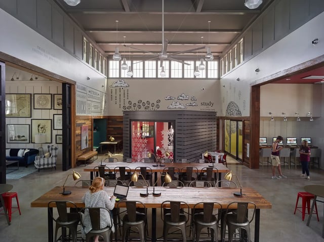 Students studying at long tables with laptops and computers study area at The Junction at College Station in College Station Student Accommodation