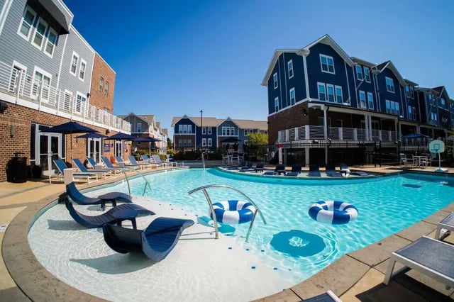 Pool with lounge chairs and inflatable rings exterior at The Dillon in Bloomington Student Accommodation