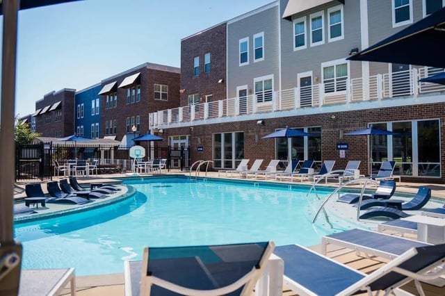 Pool with lounge chairs and buildings exterior at The Dillon in Bloomington Student Accommodation