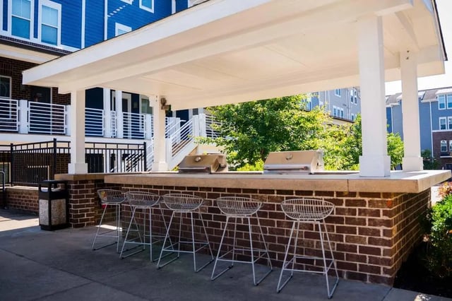 Grills and bar stools under canopy outdoor kitchen at The Dillon in Bloomington Student Accommodation
