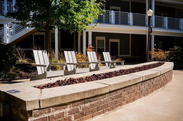 Adirondack chairs near outdoor fire pit exterior at The Dillon in Bloomington Student Accommodation