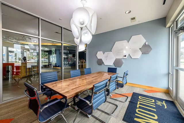 Conference table blue chairs hexagon whiteboards meeting room at The Dillon in Bloomington Student Accommodation