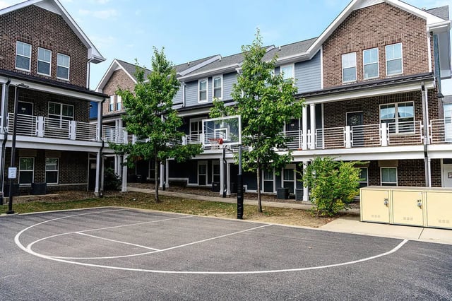 Basketball court with hoop and townhouses exterior at The Dillon in Bloomington Student Accommodation