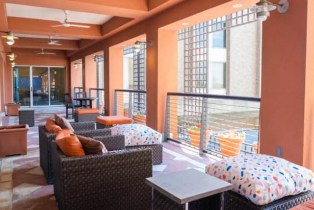 Wicker seating with orange and patterned cushions patio at Century Towers Apartments in Kansas City Student Accommodation