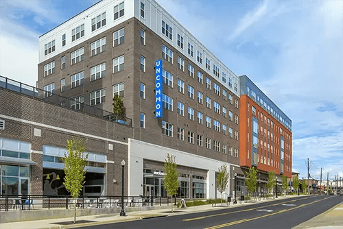 Modern brick and orange building exterior exterior at Uncommon Auburn in Auburn Student Accommodation