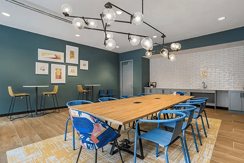 Large table blue chairs artwork communal area at Uncommon Auburn in Auburn Student Accommodation