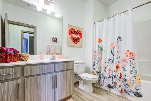 Sink toilet vanity floral shower curtain bathroom at The Boundary At West End in Greenville Student Accommodation