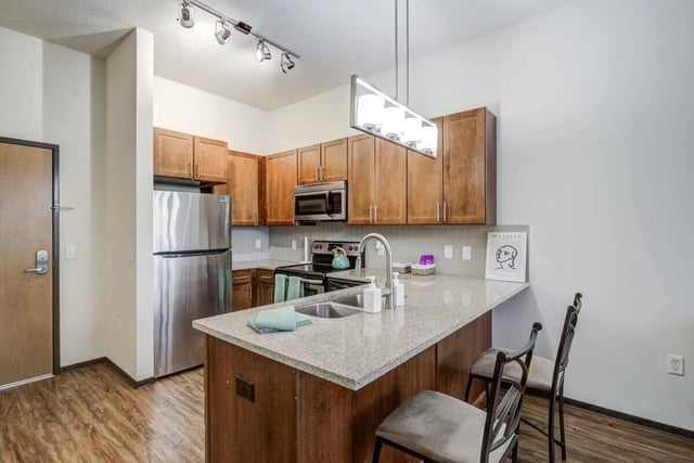 Kitchen with stainless steel appliances granite counters and island kitchen at The Knoll Dinkytown in Minneapolis Student Accommodation