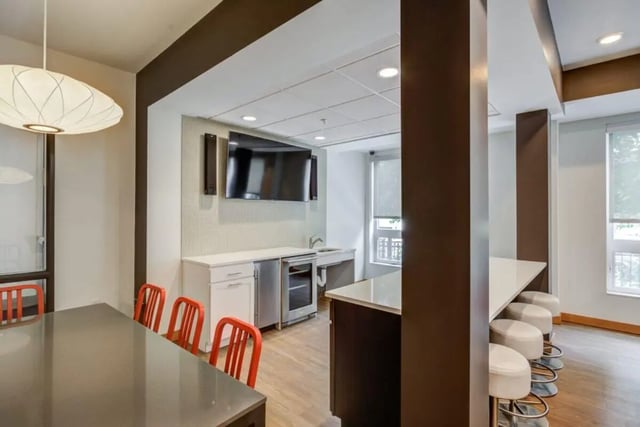 Dining table bar stools television and kitchen common area at The Knoll Dinkytown in Minneapolis Student Accommodation