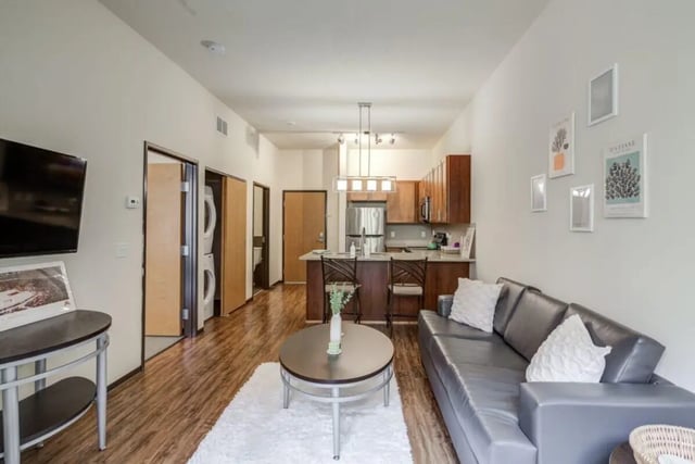 Sofa coffee table kitchen appliances and washer dryer living room at The Knoll Dinkytown in Minneapolis Student Accommodation