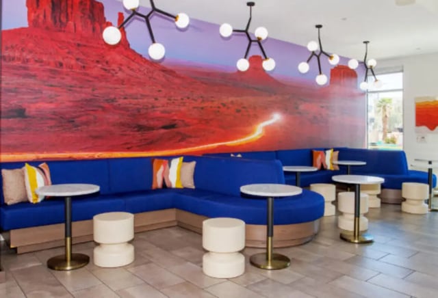 Blue sectional sofa with colorful pillows modern tables lounge area at Apollo Tempe in Tempe Student Accommodation