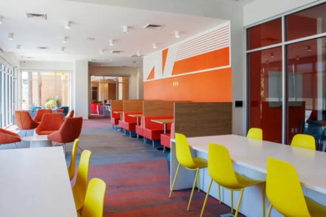 Orange chairs booth seating white table yellow chairs communal area at Apollo Tempe in Tempe Student Accommodation
