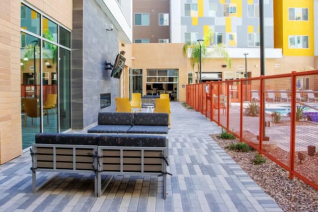 Outdoor seating area with pool and modern building exterior. at Apollo Tempe in Tempe Student Accommodation