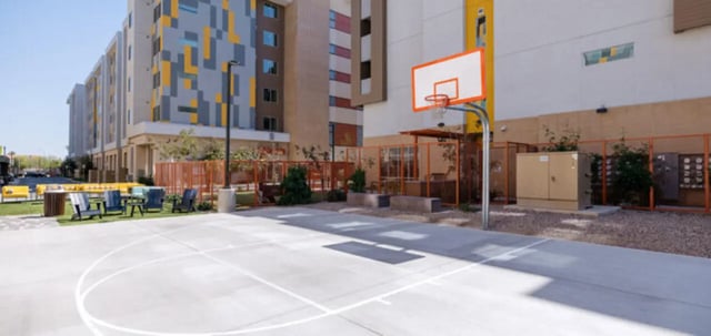 Basketball court with chairs and building exterior at Apollo Tempe in Tempe Student Accommodation