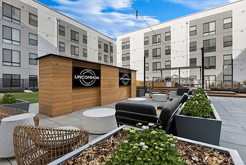 Wooden wall with screens lounge seating plants courtyard at Uncommon Boise State in Boise Student Accommodation