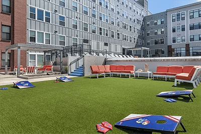 Cornhole games lounge seating outdoor courtyard exterior at Here Kansas in Lawrence Student Accommodation
