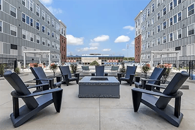 Chairs around fire pit on concrete patio exterior at Here Kansas in Lawrence Student Accommodation