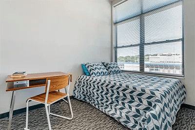 Bed desk chair with books bedroom at Here Kansas in Lawrence Student Accommodation