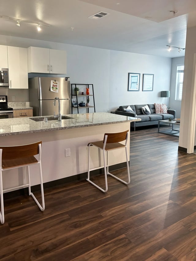 Kitchen island refrigerator chairs couch living room at Fifteen51 in Reno Student Accommodation