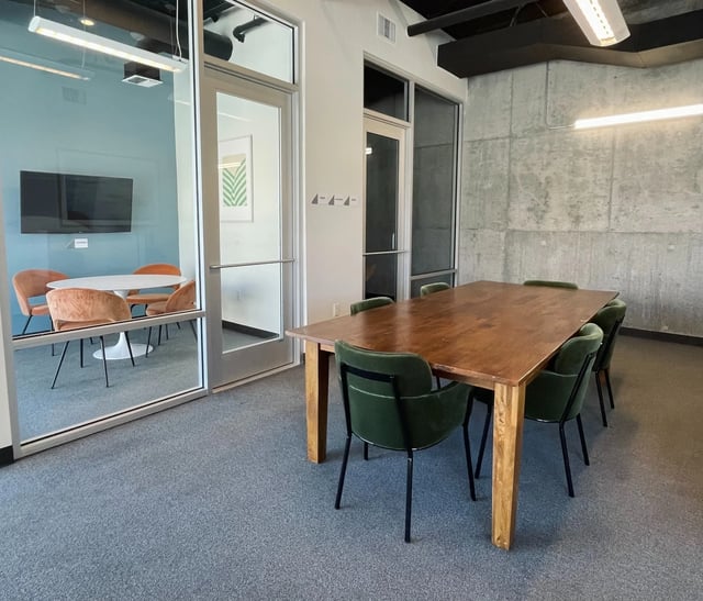 Wooden table green chairs glass meeting room at Fifteen51 in Reno Student Accommodation