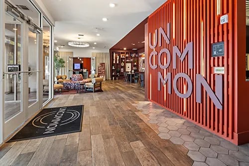 Reception area with seating and branding Living Room at Uncommon Columbus in Columbus Student Accommodation