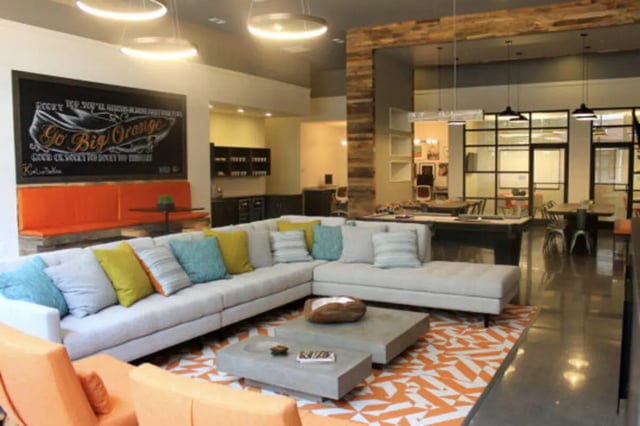 Sectional sofa with colorful pillows and coffee tables living room at The Knox Apartments in Knoxville Student Accommodation