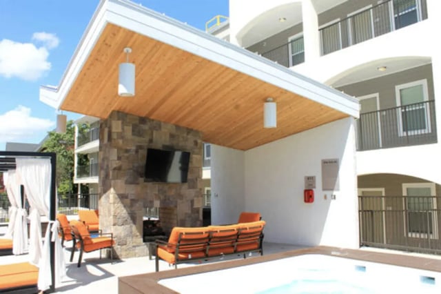 Outdoor lounge area with orange seating and pool. at The Knox Apartments in Knoxville Student Accommodation