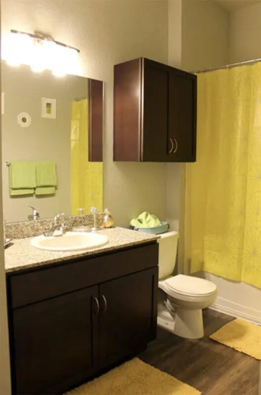 Sink toilet cabinets yellow shower curtain bathroom at The Knox Apartments in Knoxville Student Accommodation