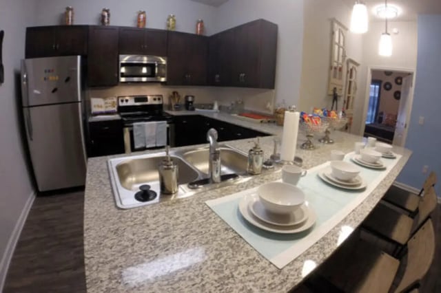 Stainless steel refrigerator dark cabinets microwave sink kitchen at The Knox Apartments in Knoxville Student Accommodation