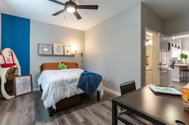 Bed with blue blanket desk and chair bedroom at The District on 5th in Tucson Student Accommodation