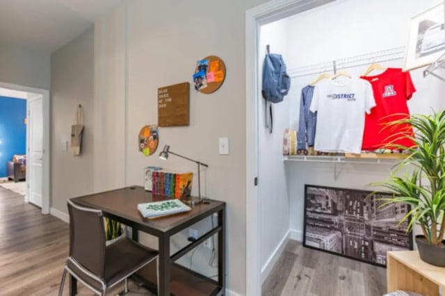 Desk lamp books and closet with clothes study area at The District on 5th in Tucson Student Accommodation