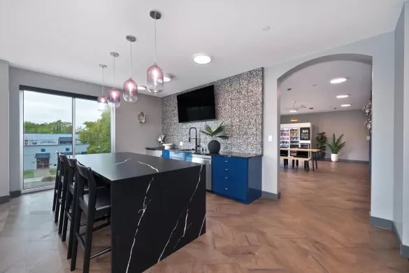 Black marble island with chairs and kitchen area at ANOVA Aggie Square in Sacramento Student Accommodation