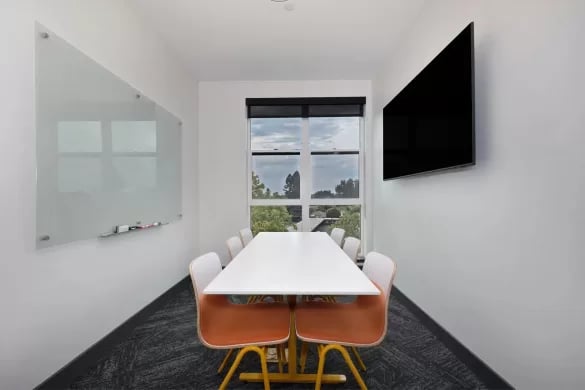 White table chairs whiteboard television study area at ANOVA Aggie Square in Sacramento Student Accommodation