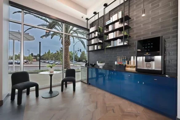 Seating area with coffee machine and books common area at ANOVA Aggie Square in Sacramento Student Accommodation