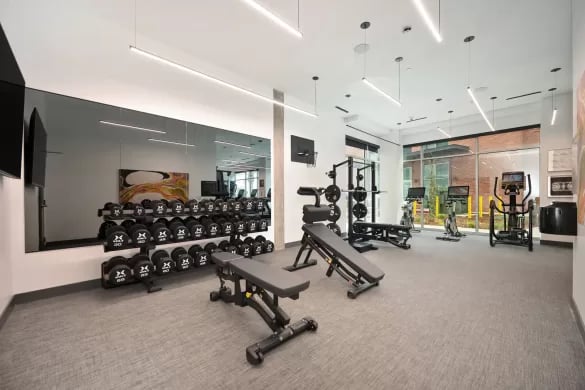 Dumbbells benches weight rack cardio machines gym at ANOVA Aggie Square in Sacramento Student Accommodation