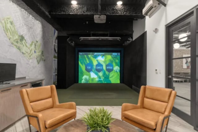 Golf simulator room with chairs and screen playing area at ANOVA uCity Square in Philadelphia Student Accommodation