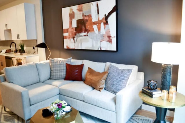 White sectional sofa with decorative pillows and coffee table living room at ANOVA uCity Square in Philadelphia Student Accommodation