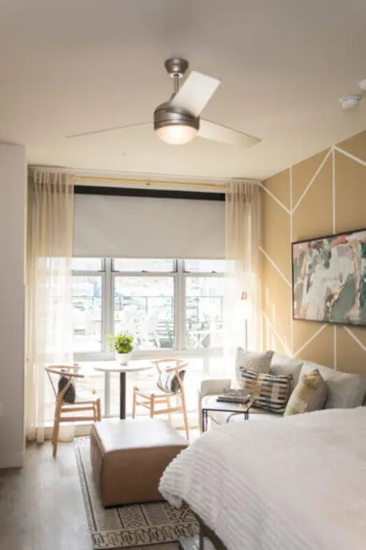 Bed sofa table chairs ottoman living room at ANOVA uCity Square in Philadelphia Student Accommodation