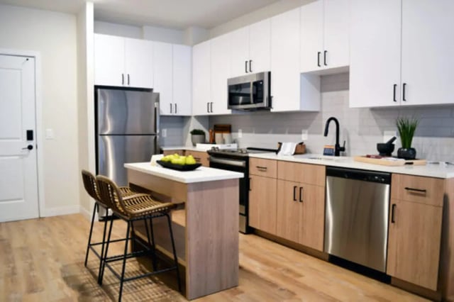 Kitchen with island refrigerator and chairs Kitchen at ANOVA uCity Square in Philadelphia Student Accommodation