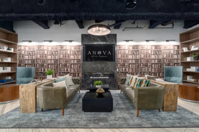 Two sofas coffee table fireplace and bookshelves Living room at ANOVA uCity Square in Philadelphia Student Accommodation
