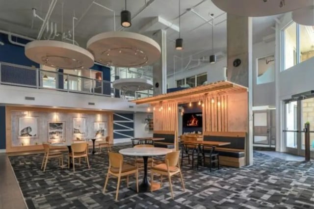 Tables chairs booths with fireplace and artwork common area at The District on Apache in Tempe Student Accommodation