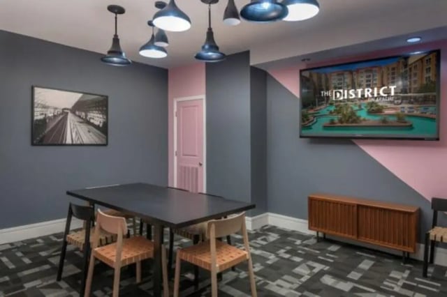 Table chairs artwork and television living room at The District on Apache in Tempe Student Accommodation