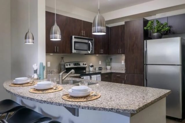 Granite counter stainless appliances pendant lights kitchen at The District on Apache in Tempe Student Accommodation