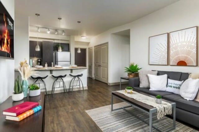 Sofa coffee table artworks living area and kitchen. at The District on Apache in Tempe Student Accommodation