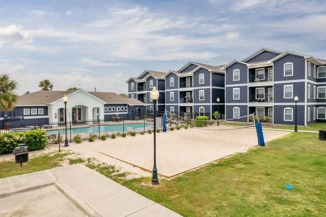 Apartment buildings pool and volleyball court exterior at The Kristi in Corpus Christi Student Accommodation