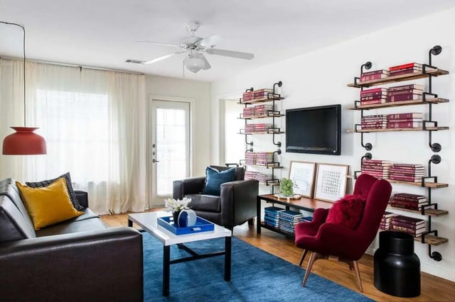 Sofa bookshelves TV framed art chairs living room at The Kristi in Corpus Christi Student Accommodation