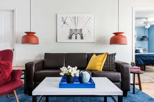 Dark leather couch with yellow pillows living room at The Kristi in Corpus Christi Student Accommodation
