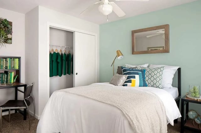 Bed with green shirts in closet and desk bedroom at The Kristi in Corpus Christi Student Accommodation